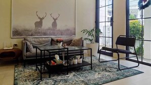 A living room with a sofa, coffee table, and a large window with a wreath.