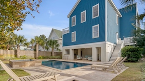 A two-story house with a swimming pool, outdoor seating, and a fenced yard. - Luxury, Oceanview Beach Home w/ Private Pool & Outdoor Kitchen, Hot Tub, Rooftop Deck, & Elevator! (Isle Of Palms)