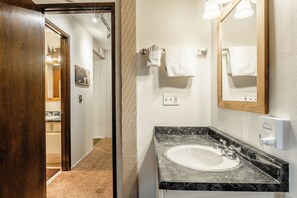A bathroom with a marble sink, a large mirror, and a towel rack. - Midtown 1BR, Pool & Spa, Close to Shops 538 (Mammoth Lakes)