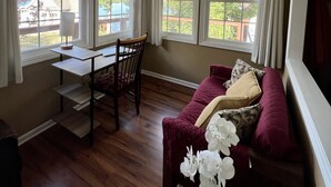 A room with a ceiling fan, a dining table with chairs, a sofa with cushions, and a window with curtains. - Charming home with lake views (Boydton)