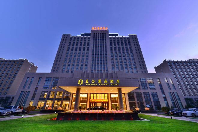 Un hotel con una entrada destacada, varios pisos y una fachada bien iluminada.