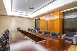 A conference room with a long table, chairs, a projector, and a wooden wardrobe. - Shenghe Regent Hotel (Changge)