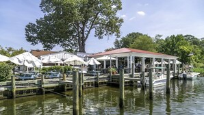 A waterfront restaurant with outdoor seating, a covered patio, and docked boats. - Waterfront Home w Pool, Pier & Parking Mins to Annapolis (Arnold)