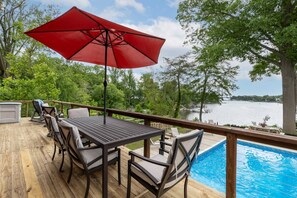 A wooden deck with a pool table, chairs, and a red umbrella. - Waterfront Home with Stunning Views, Pool, Pier & Parking Mins to Annapolis (Arnold)