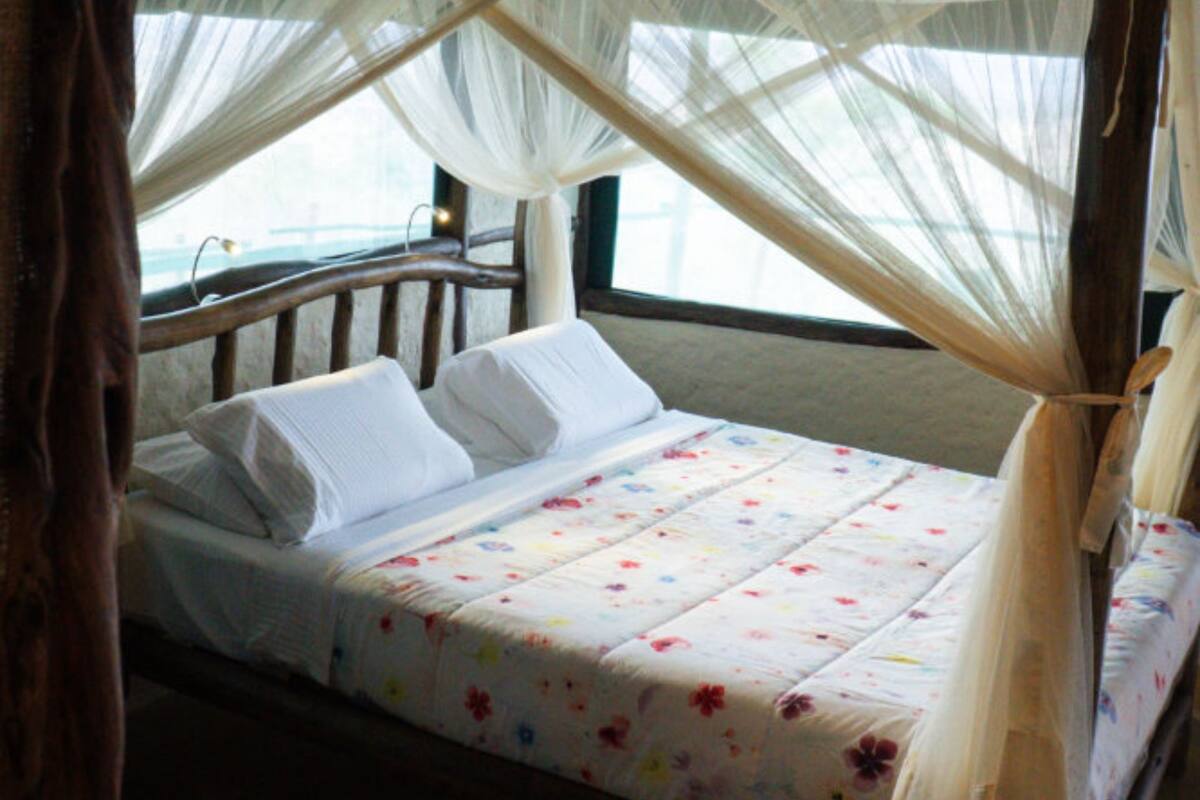Ein Bett mit Baldachin, einem Holzkopfende und einem floralen Bettbezug.