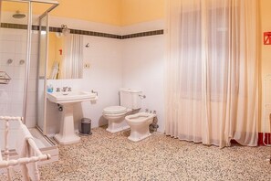 Une salle de bain équipée d’une douche, d’un lavabo, de toilettes et d’un bidet.