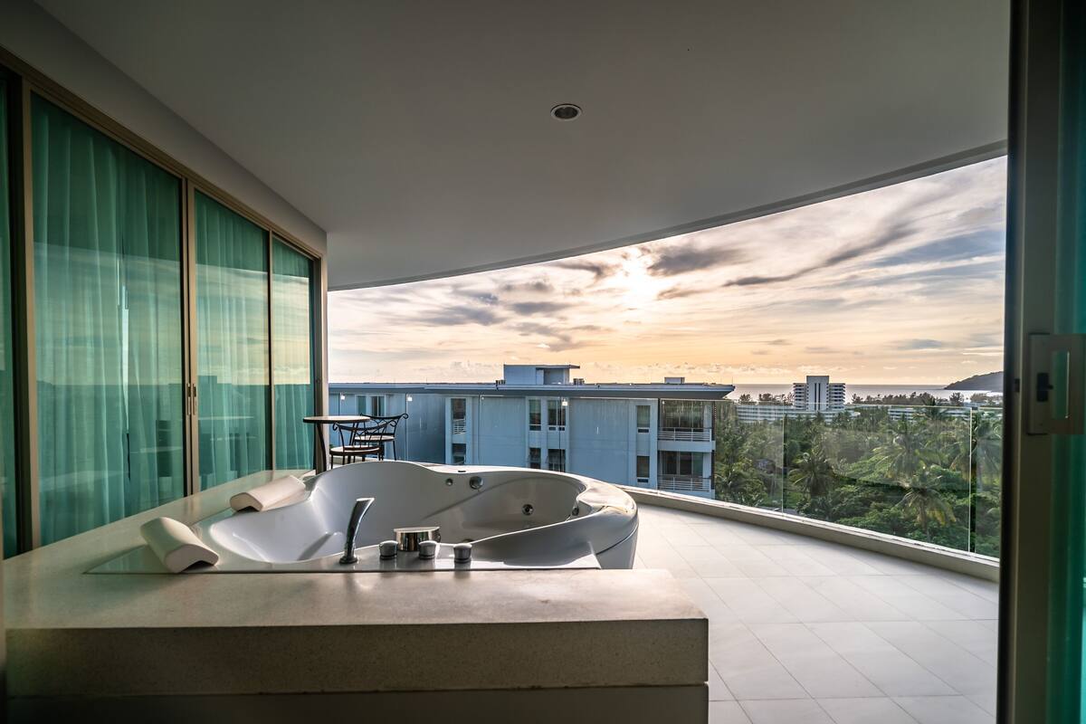 A modern bathroom with a freestanding bathtub, a glass shower enclosure, and a large window offering a city view.