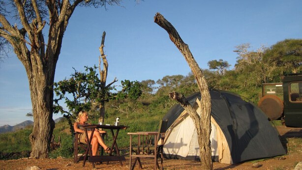 A tent set up in a natural environment with a table and chairs nearby. - Cheetah Campsite Lumo (Mtito Andei)