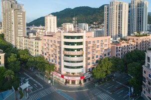 Un edificio de varios pisos con un patio central, rodeado por otros edificios y árboles.