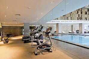 A gym with treadmills and a pool area. - Arcadia Hotel (Jiangyin)
