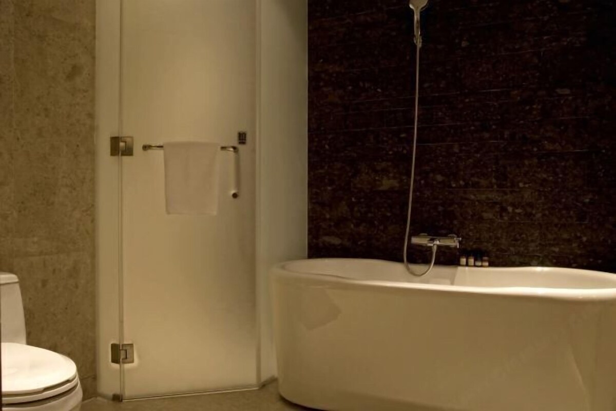 A bathroom with a toilet, a bathtub, and a shower.