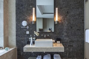 A modern bathroom with a rectangular sink, two wall-mounted lights, a large mirror, and a towel rack. - Arcadia Hotel (Jiangyin)
