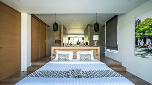 Ein modernes Hotelzimmer mit einem großen Bett, einem Holzschrank und Blick auf die Stadt durch große Fenster.