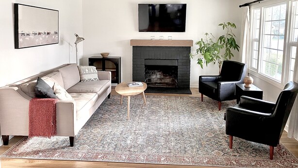 Una sala de estar moderna con chimenea, un sofá, una mesa de centro y un televisor.