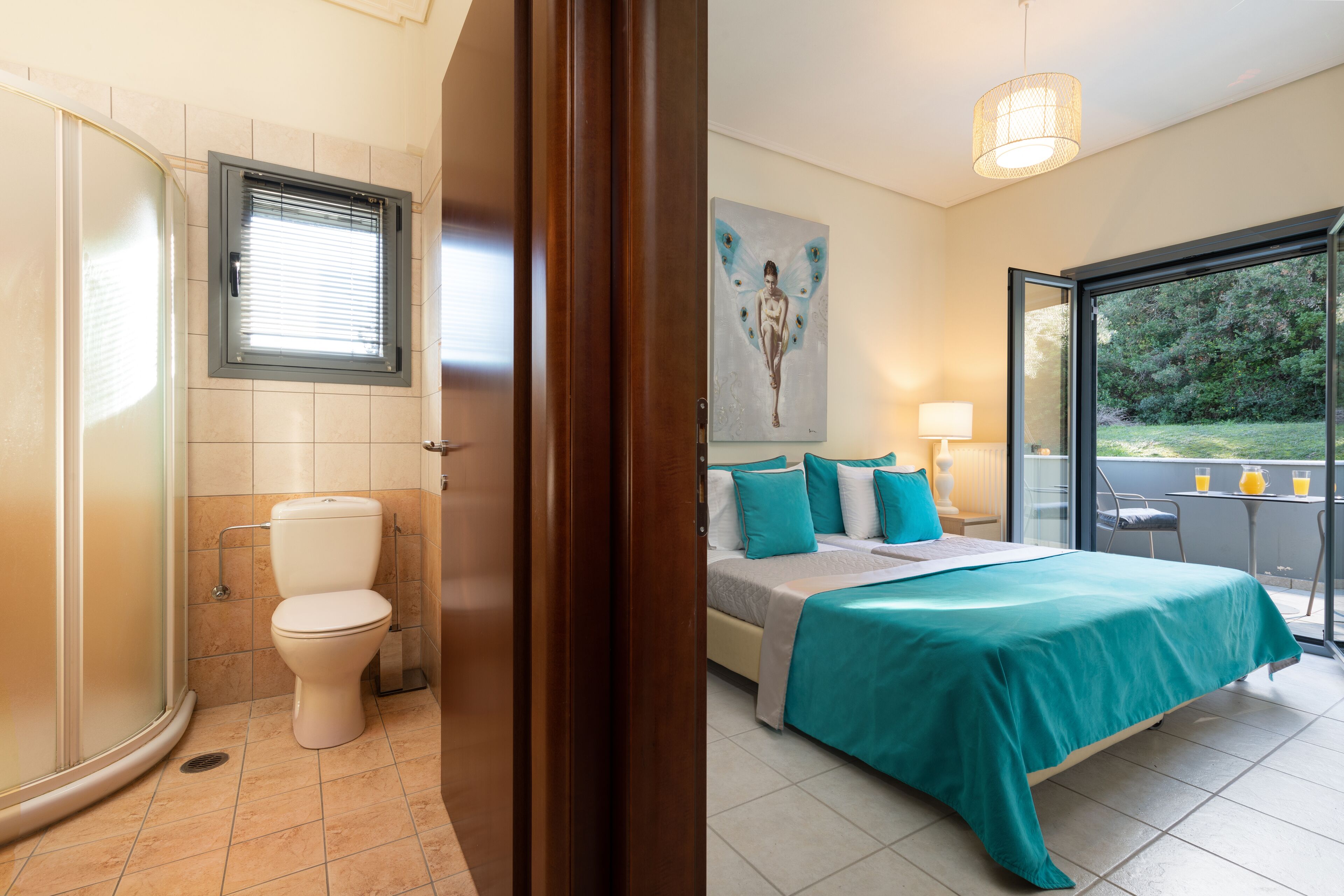 Une salle de bain équipée de toilettes, d’une douche et d’une porte en verre donnant sur un balcon.
