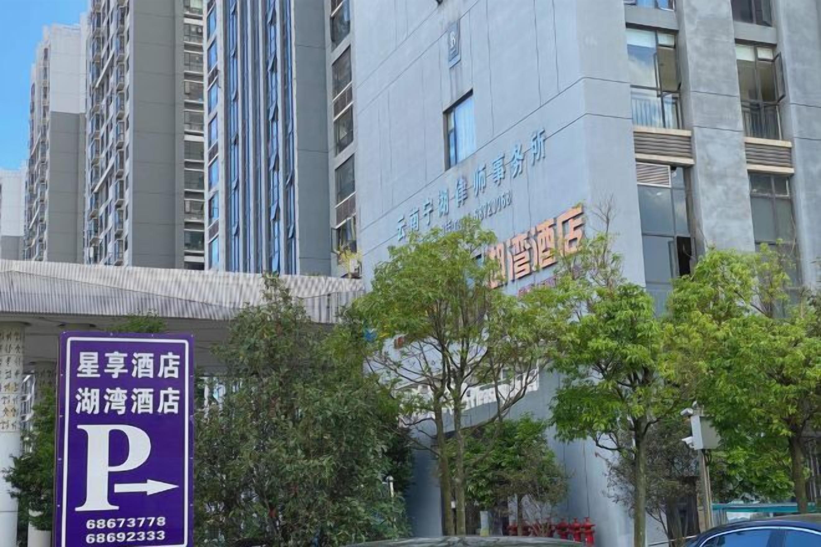 Un hotel con un letrero destacado que indica un estacionamiento.