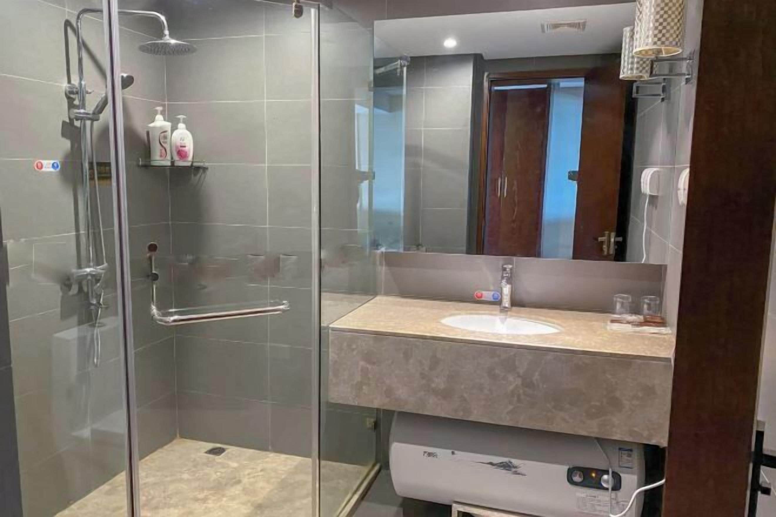 Une salle de bain moderne avec une douche à parois de verre, un meuble-lavabo et un grand miroir.