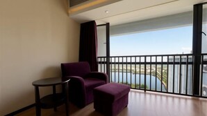 A balcony with a view of a body of water and buildings. - Huwan Hotel (Anning)