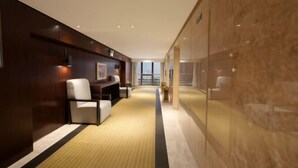 A modern hotel lobby with a long corridor, seating area, and a glass wall. - Huwan Hotel (Anning)