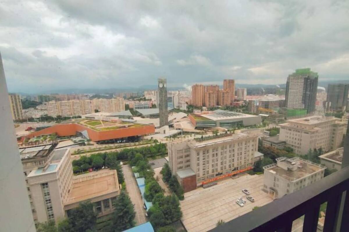 A cityscape with high-rise buildings, a prominent clock tower, and a large open plaza.
