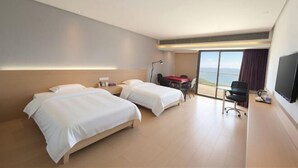 A hotel room with two beds, a desk, a chair, a TV, and a large window with a view. - Huwan Hotel (Anning)