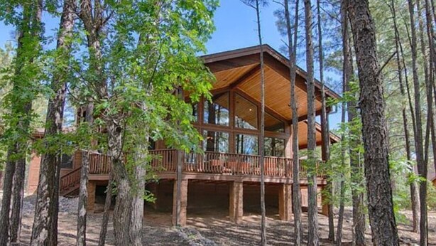 A wooden cabin with a balcony, surrounded by trees. - Cabin 5 Torreon with Hot Tub (Show Low)