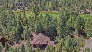 A house surrounded by a dense forest with a golf course nearby. - Cabin 5 Torreon with Hot Tub (Show Low)