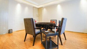 Un espace repas moderne comprenant une table ronde, quatre chaises et une petite table d’appoint.