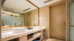 Une salle de bain moderne avec deux lavabos, un grand miroir et un meuble-lavabo en bois.