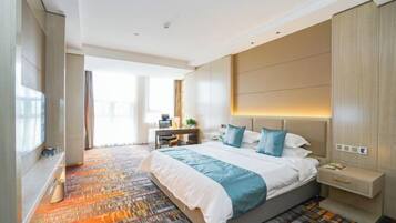 A modern hotel room with a large bed, a bedside table, a nightstand, and a view of the outdoors.