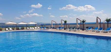 Una piscina al aire libre de temporada, camas de piscina gratis. Flora Hotel