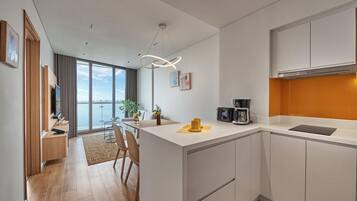 A modern kitchen with a central island, white cabinetry, and a view of the city.