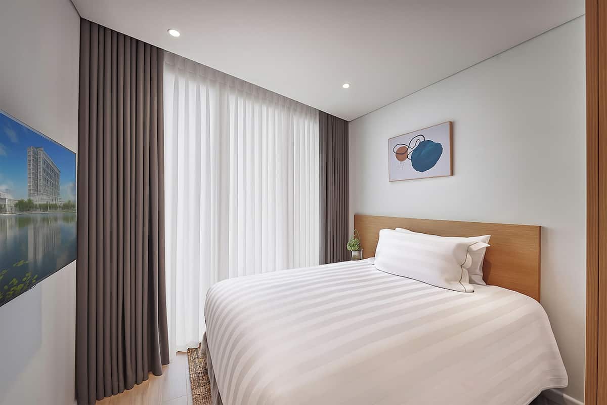 Una habitación de hotel con una cama grande, vistas a un edificio y un cuadro en la pared.