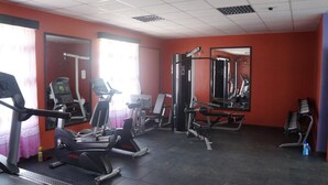 A gym with cardio machines, weightlifting equipment, and mirrors. - Kabarak University Guesthouse (Eldama Ravine)