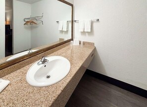 A bathroom with a sink, mirror, towel rack, and a shower area. - Motel6 Mesa, AZ - Downtown (Mesa)