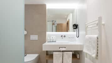 A modern bathroom with a white sink, toilet, and towel rack.