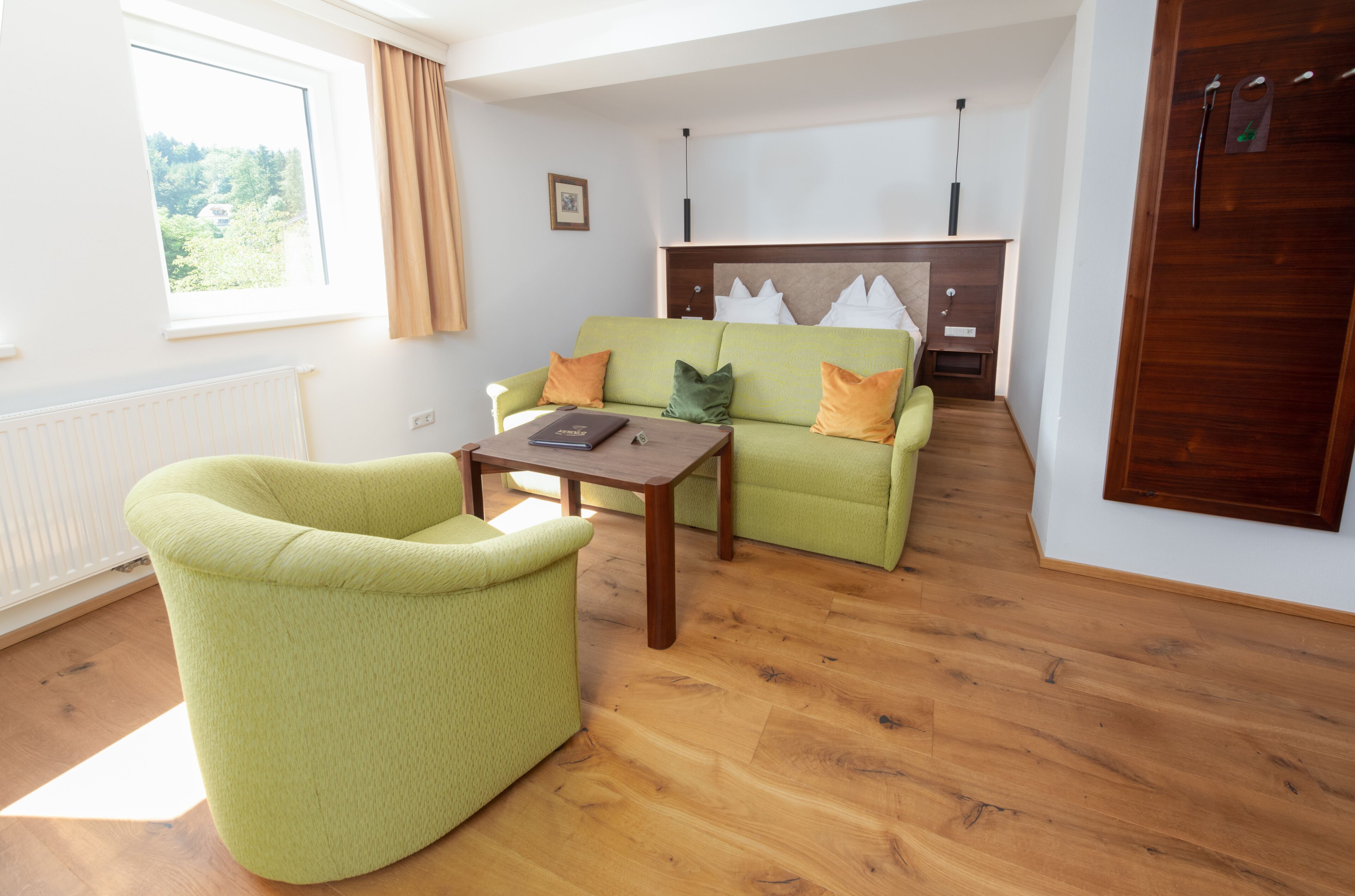Ein Wohnzimmer mit einem grünen Sofa, einem Holztisch und einem Kamin.