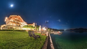 A waterfront hotel with outdoor seating and a boat dock. - Hotel Stadler am Attersee (Unterach am Attersee)