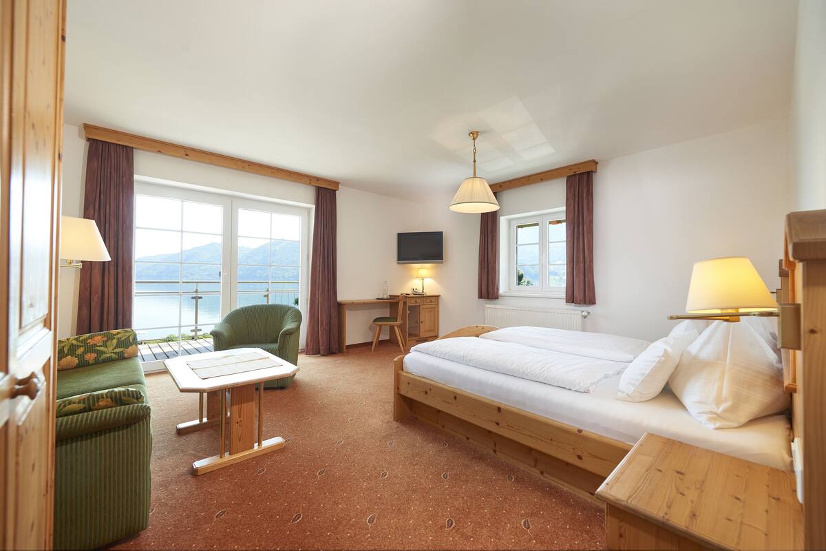 Une chambre d’hôtel équipée d’un lit, d’un bureau, d’une chaise, d’un canapé et d’une télévision.