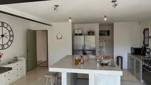 A modern kitchen with a central island, stainless steel appliances, and a minimalist design. - Mas Arietis  (Saint-Rémy-de-Provence)