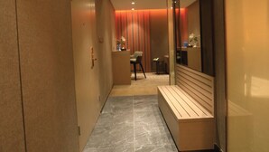 Un couloir avec un banc, un bureau et une chaise.