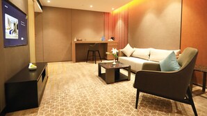 Un salon moderne comprenant un canapé, un fauteuil, une table basse et un petit bureau avec une chaise.