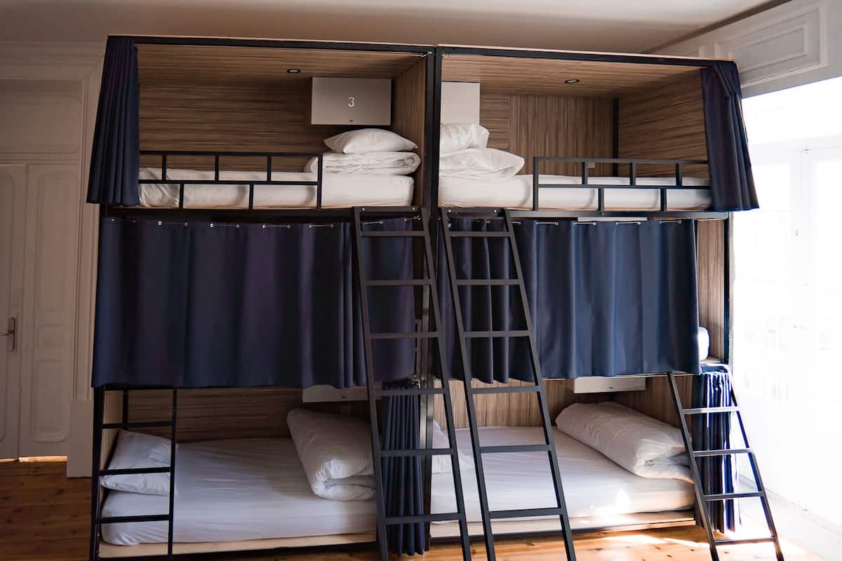 A bunk bed room with a wooden headboard, a ladder, and a small shelf.