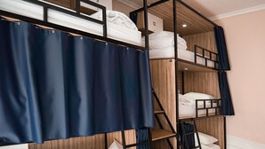 A bunk bed room with a wooden headboard, a curtain, and a number sign indicating room 9.