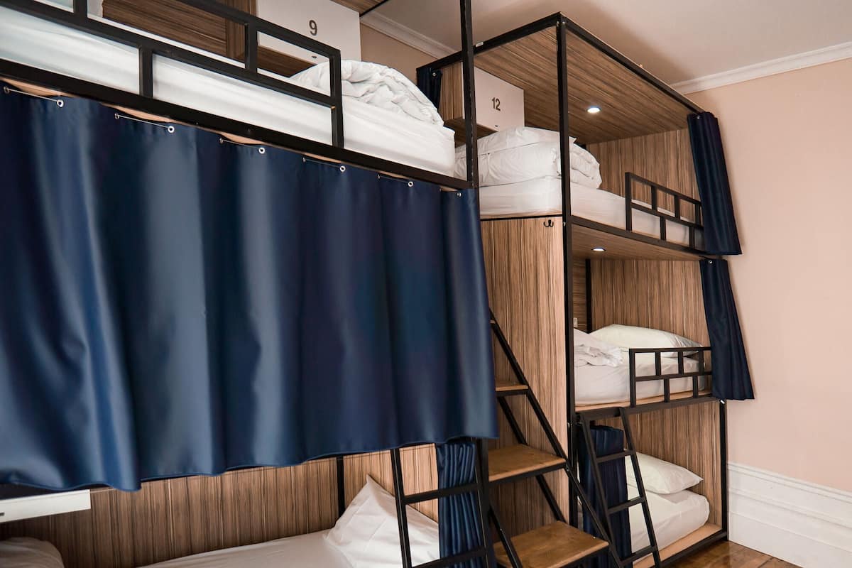 A bunk bed room with a wooden headboard, a curtain, and a number sign indicating room 9.