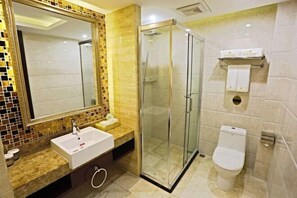 A modern bathroom with a glass-enclosed shower, a white sink, and a toilet. - Jin Cheng Hotel (Gangu)