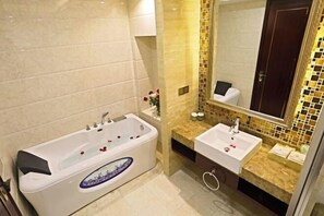 A bathroom with a bathtub, a sink, and a mirror. - Jin Cheng Hotel (Gangu)