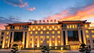A hotel with a traditional architectural style, featuring a large entrance and multiple windows.