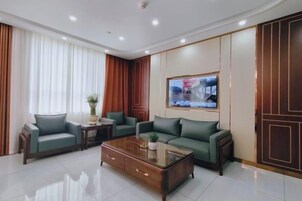 A modern living room with a sofa set, a coffee table, and a television mounted on the wall.