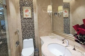 A bathroom with a toilet, bidet, sink, and a mirror with a floral design. - Fu'an Exhibition Hotel (Fu'an)